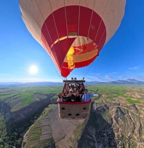 A hot air balloon with passengers over a valley. 4