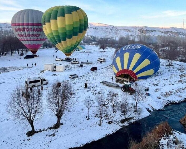 Three hot air balloons over a snowy landscape with a river. 5