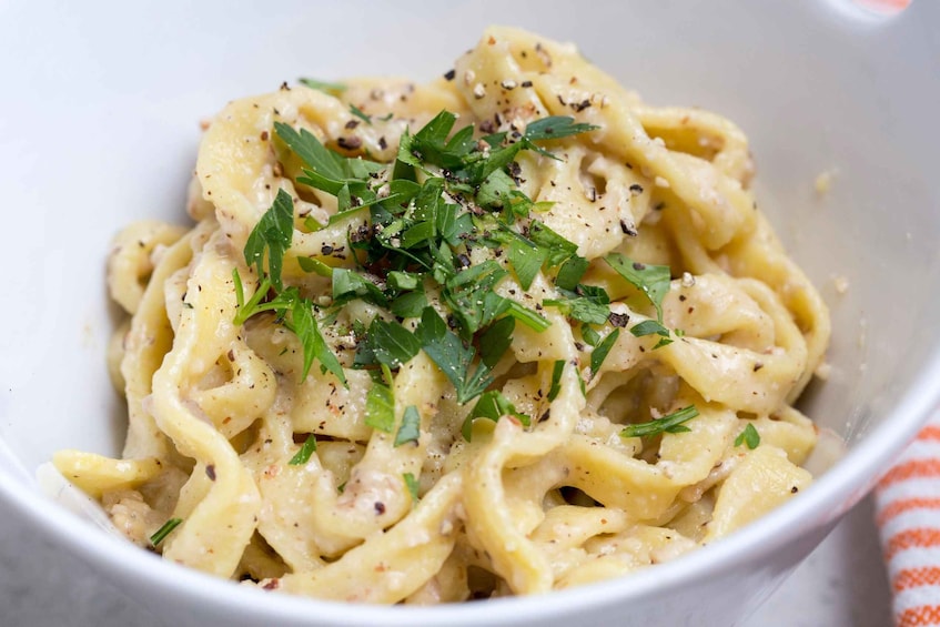 A bowl of pasta garnished with herbs. 4