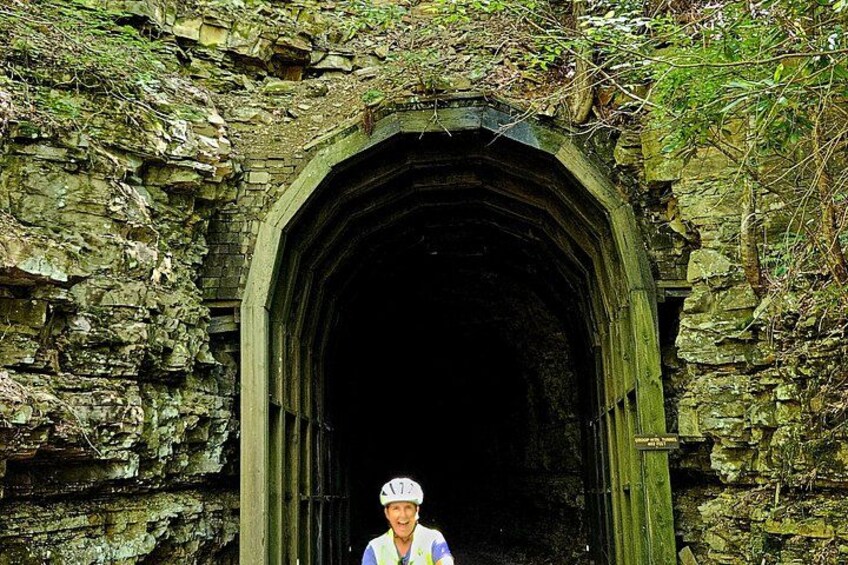 A stone archway with a person standing in front of it. 3