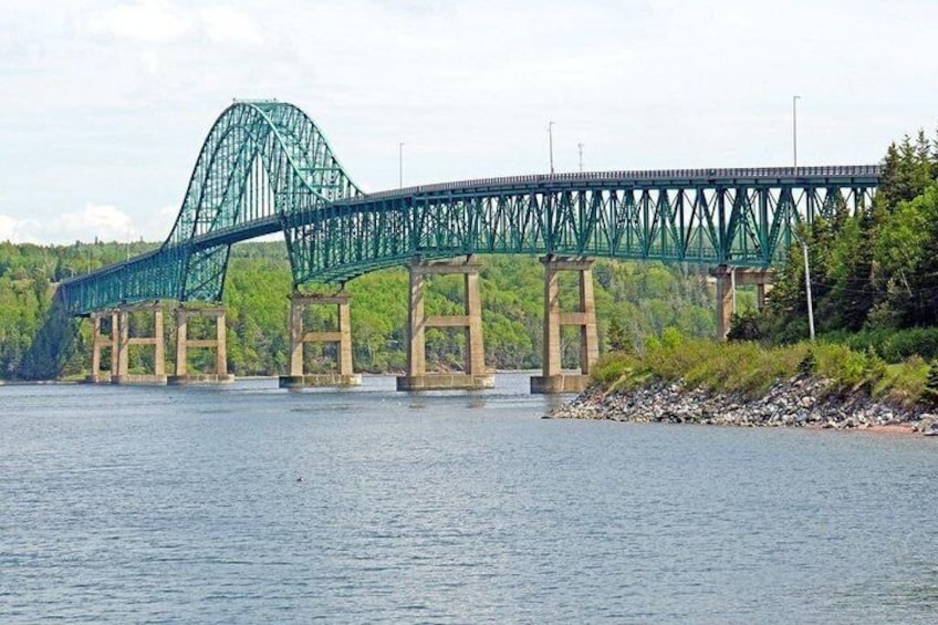 Un grande ponte in acciaio con un arco caratteristico che sovrasta un fiume, circondato dal verde. 5