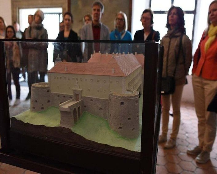 A model of a castle with two towers and a central building, displayed in a case. 2