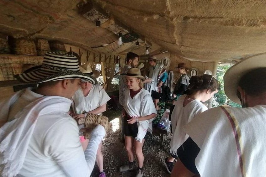 Un groupe de personnes vêtues de costumes traditionnels s’est rassemblé sous un abri rustique. 3