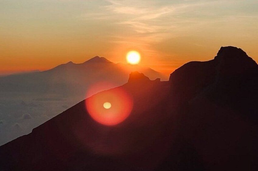 Un paysage de montagne au coucher du soleil, avec le soleil bas à l’horizon. 3