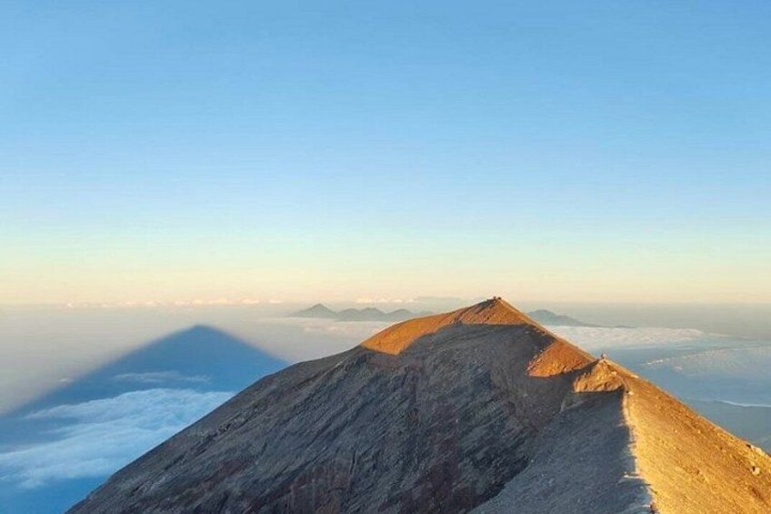 Un sommet de montagne, avec un ciel dégagé et des nuages en contrebas. 2