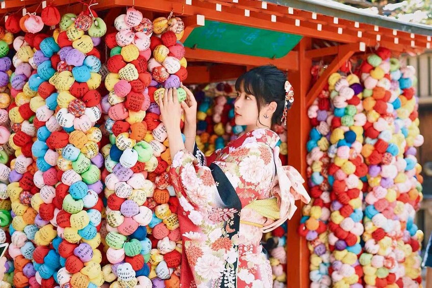 A person in a kimono interacting with colorful, patterned balls. 5