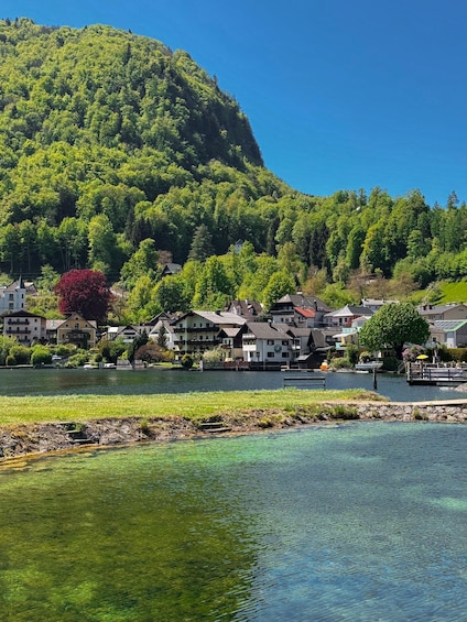 A lakeside village with houses, a dock, and a hill in the background. 3