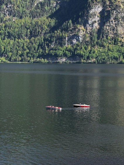 Two boats on a calm lake with a forested mountain in the background. 5