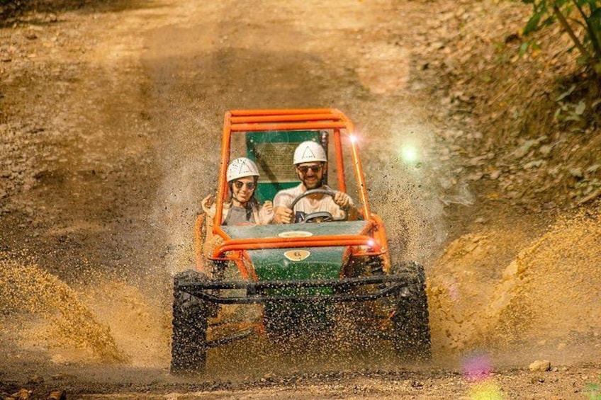 A vehicle driving on a dirt road with a person wearing a helmet. 5