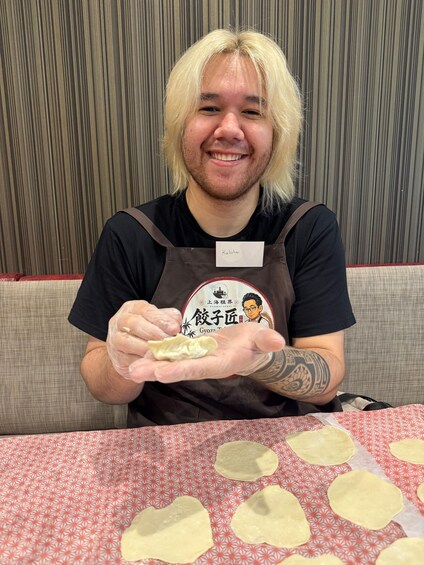 A person holding a dumpling with a name tag reading 'Kaluha'. 2
