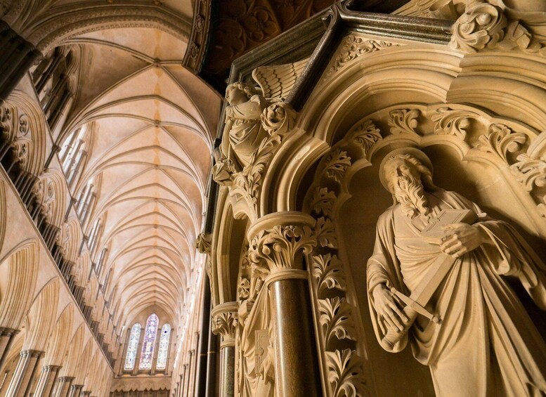 A cathedral interior with Gothic architecture, including pointed arches, ribbed vaults, and a large stained glass window. 3