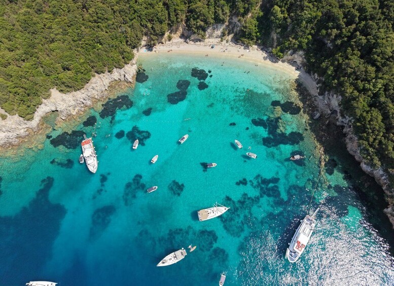 A turquoise bay with boats anchored and a sandy beach. 2