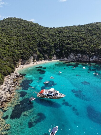 A coastal area with clear turquoise waters, a sandy beach, and a boat named 'Sailbobs of Cruis' anchored near the shore. 3