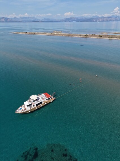 A boat anchored in calm waters with a mountainous landscape in the background. 5