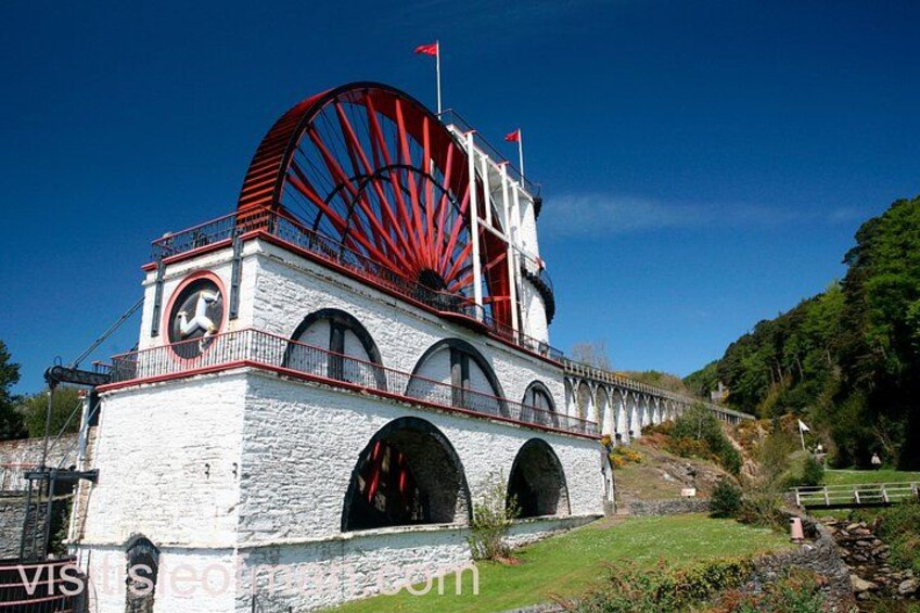 Una rueda hidráulica con una estructura roja, un reloj y un puente. 2