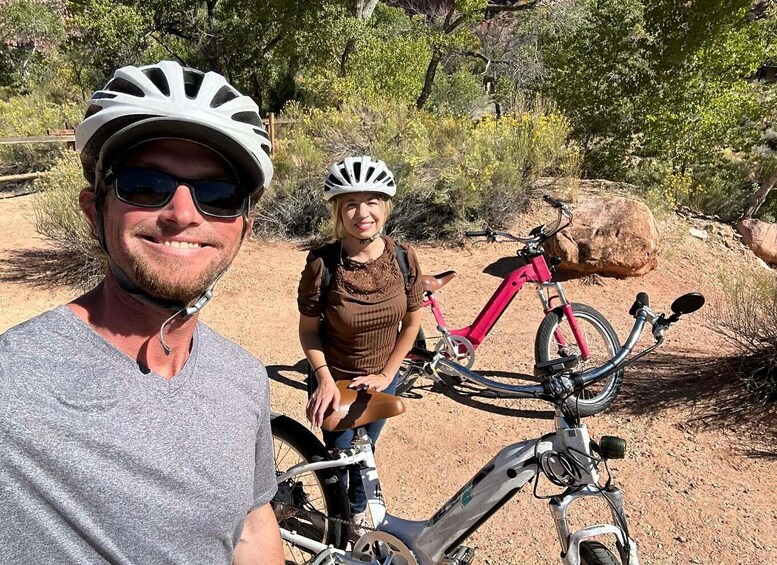 Two people with bicycles in a natural, rocky outdoor setting. 3