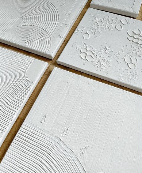 A collection of white tiles with various embossed patterns. 5