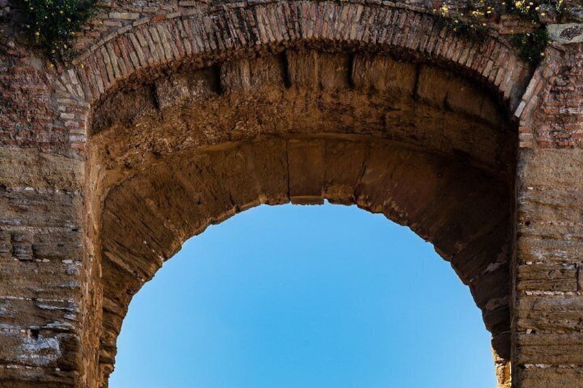 An arched stone bridge with a clear blue sky above. 2