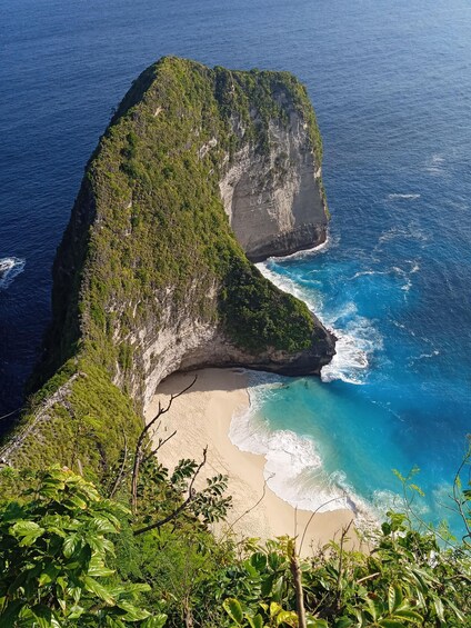 A coastal landscape with a prominent cliff and a beach. 1