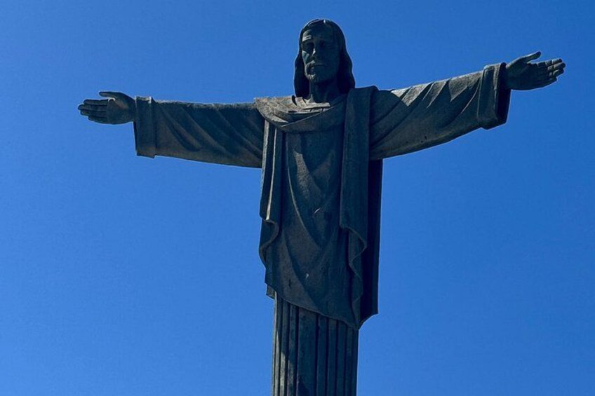 En staty med utsträckta armar mot en klarblå himmel. 5