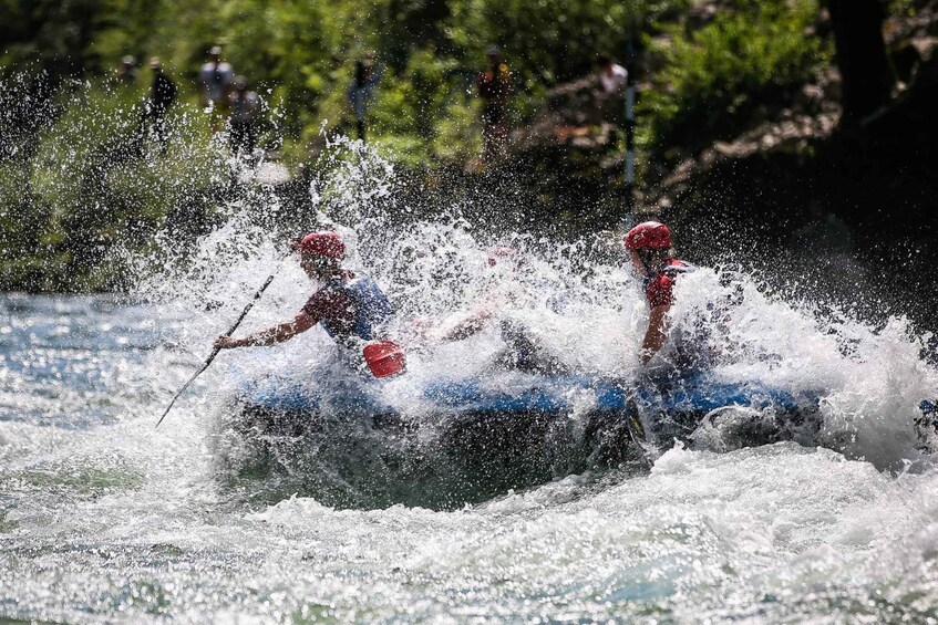 Two people in a kayak navigating through a turbulent river. 4