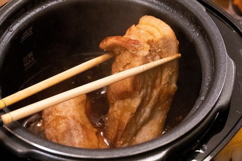 A cooking pot with a piece of meat being cooked. 5