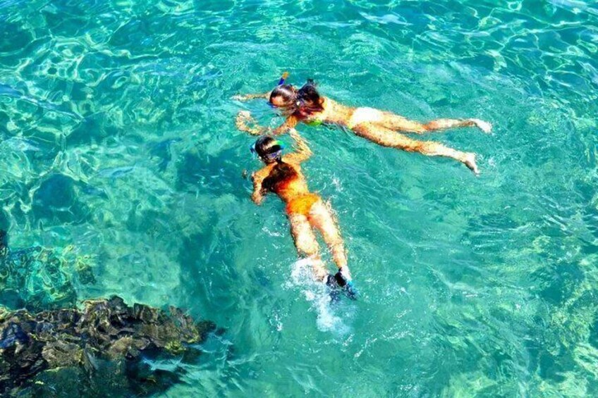 Dos personas nadando en aguas claras y azules. 4