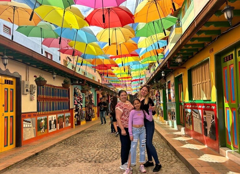 A colorful street with vibrant umbrellas overhead and a cobblestone path. 5