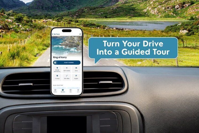 Un teléfono inteligente sujeto al tablero de un coche mostrando una aplicación de recorrido guiado y una vista panorámica del paisaje. 1