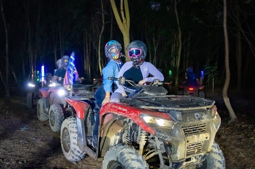 To personer på ATV'er i en skov om natten. 1