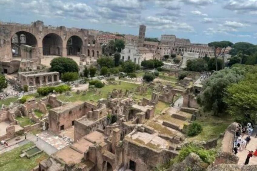 Ancient ruins with arches and a large building in the background. 5