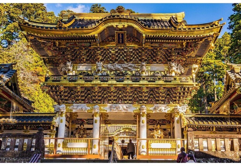 A traditional Japanese temple with ornate golden decorations and statues. 1