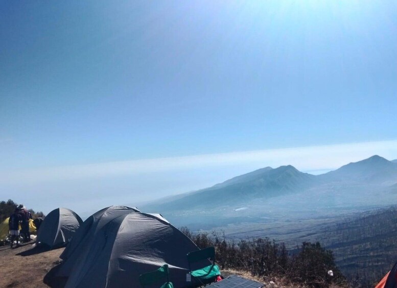 A mountainous landscape with tents and a clear sky. 3