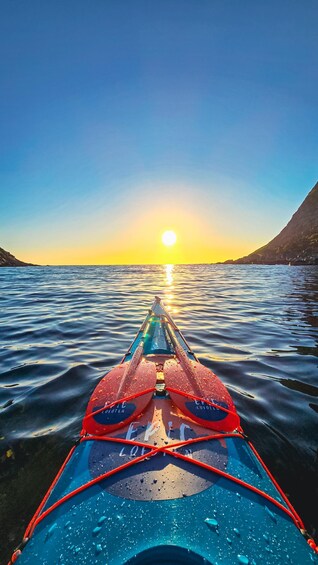 A kayak with 'LOEOTEN' written on it, facing the sun over calm water. 4