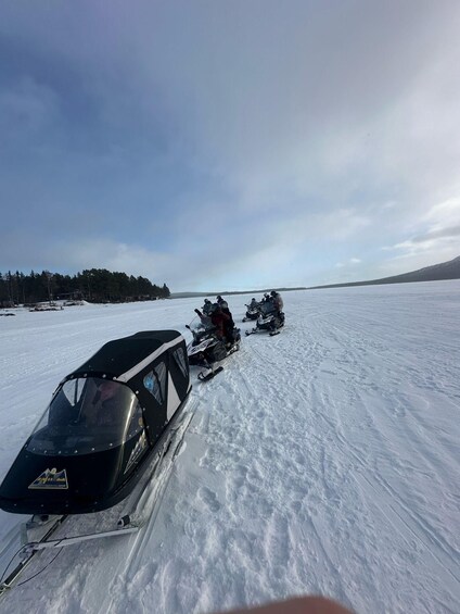 A snowmobile on a flat, snowy landscape with a clear sky. 4