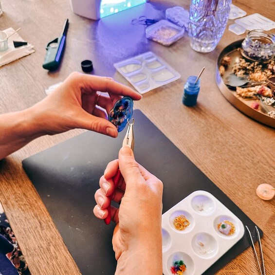 A person painting a resin coaster with a palette knife. 2