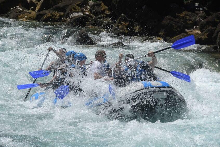A group of people kayaking through a turbulent river. 1