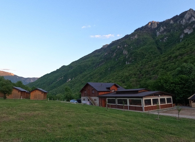 A mountainous landscape with a wooden house and a garage. 5