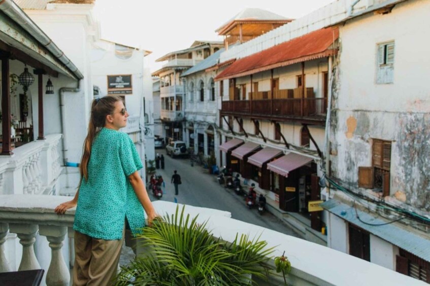 A person overlooking a street with traditional buildings and parked motorcycles. 2