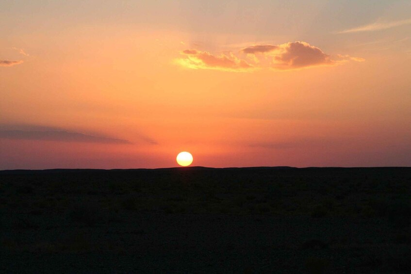 Auringonlasku tasaisella maisemalla, jossa aurinko on selvästi näkyvissä. 5