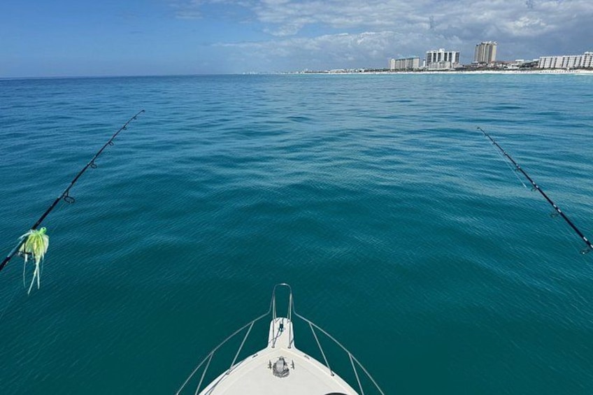 Un bateau sur des eaux turquoise et calmes, avec une vue sur les gratte-ciel d’une ville en arrière-plan. 2