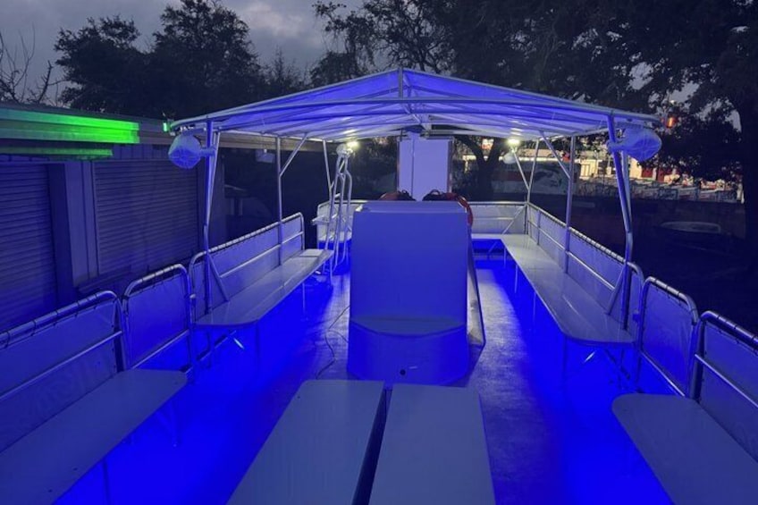 Cubierta de barco con iluminación azul, barandas de metal y bancos. 4