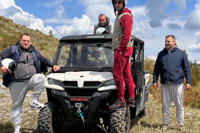 Eine Gruppe von Personen steht neben einem weißen Geländewagen mit der Aufschrift 'CEMOTO'. 4