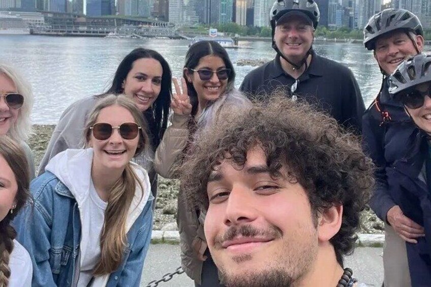 A group of people near a waterfront with a city skyline in the background. 5