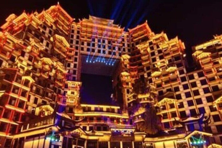 A multi-story building with illuminated balconies and a central open area. 2