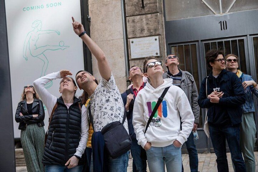 A group of people standing in front of a building with a sign that says 'COMING SOON'. 5