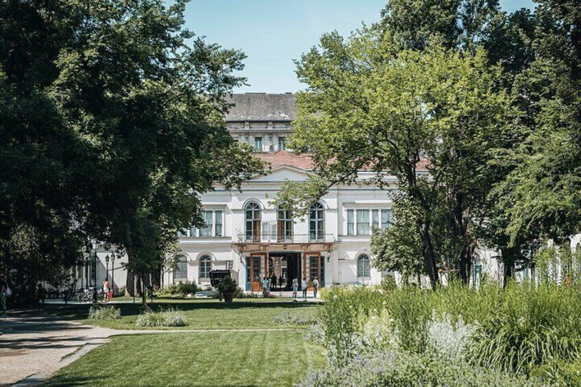 A historic building with a garden in front. 4