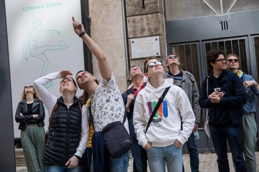 Un grupo de personas de pie frente a un edificio con un cartel que dice 'PRÓXIMAMENTE'. 5