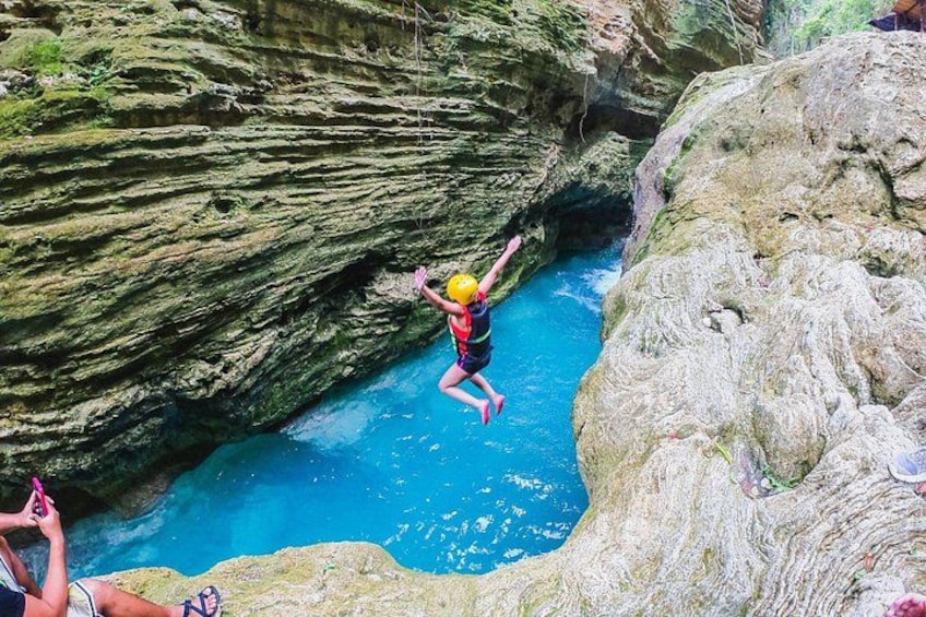 A person jumping from a cliff into a body of water. 2