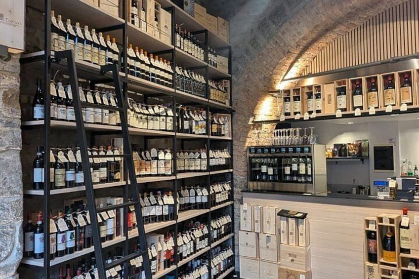 A wine cellar with shelves of wine bottles and a bar area. 5